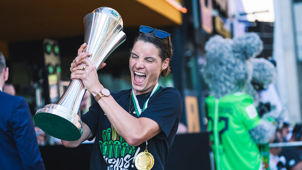 Die VfL-Wolfsburg-Spielerin Dominique Janssen hält jubelnd den Pokal in den Händen.
