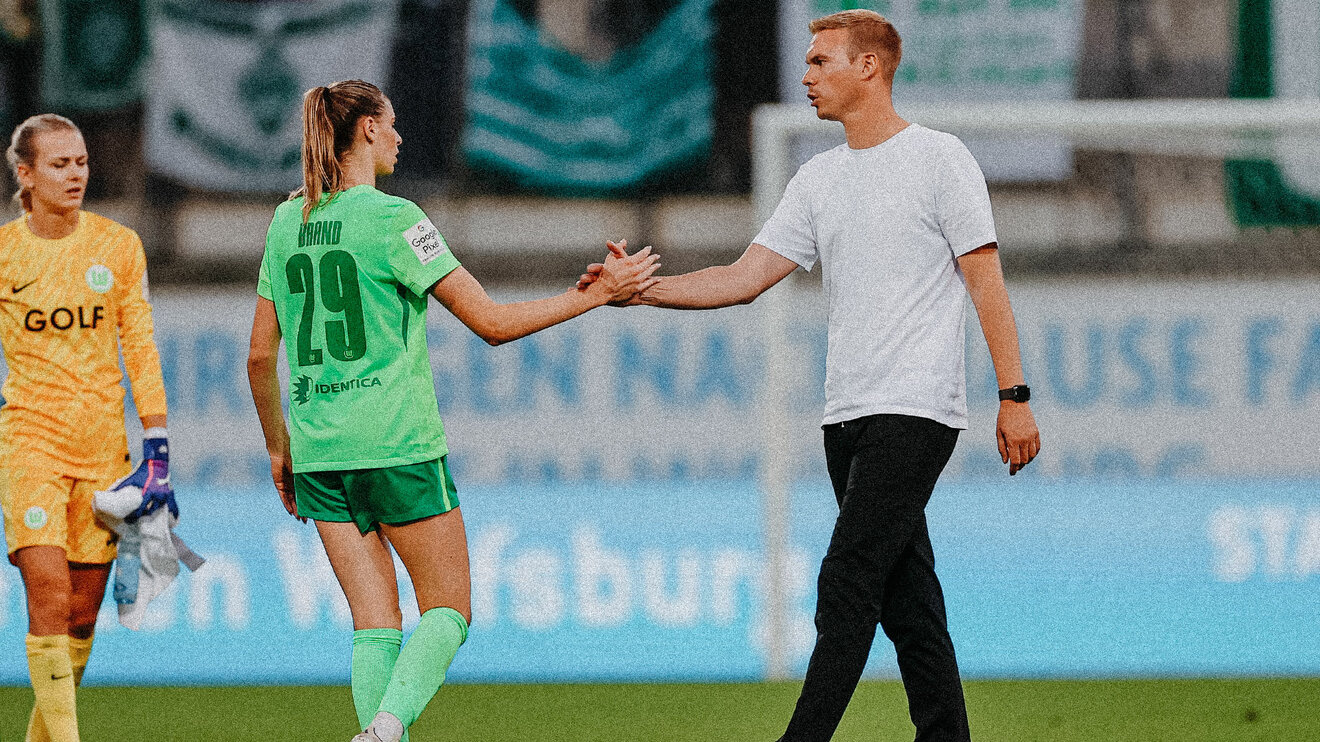 Der VfL-Wolfsburg-Trainer Tommy Stroot klatscht mit Jule Brand ab.