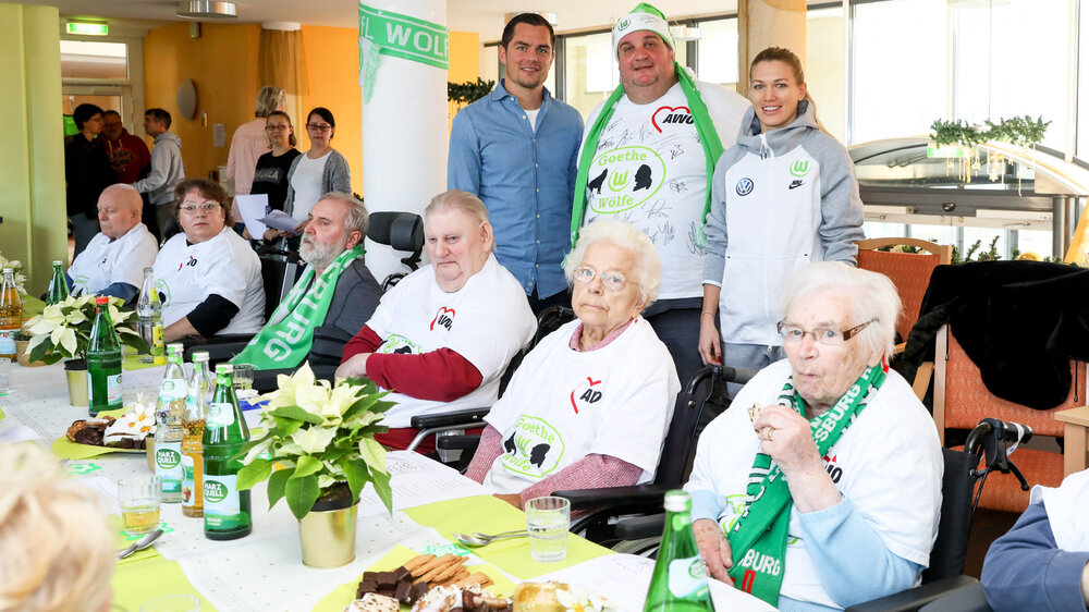 Marcel Schäfer und Lara Dickenmann mit Bewohnern und Mitglieder des Fanclubs im AWO-Seniorenheim.