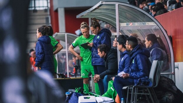 Kim Kulig vom VfL Wolfsburg erklärt der Spielerin Kristin Demann am Spielfeldrand etwas auf ihrem Tablet.