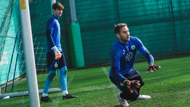 Niklas Klinger, Torwart des VfL Woflsburg, fällt auf seine rechte Seite und versucht, den Ball zu halten.
