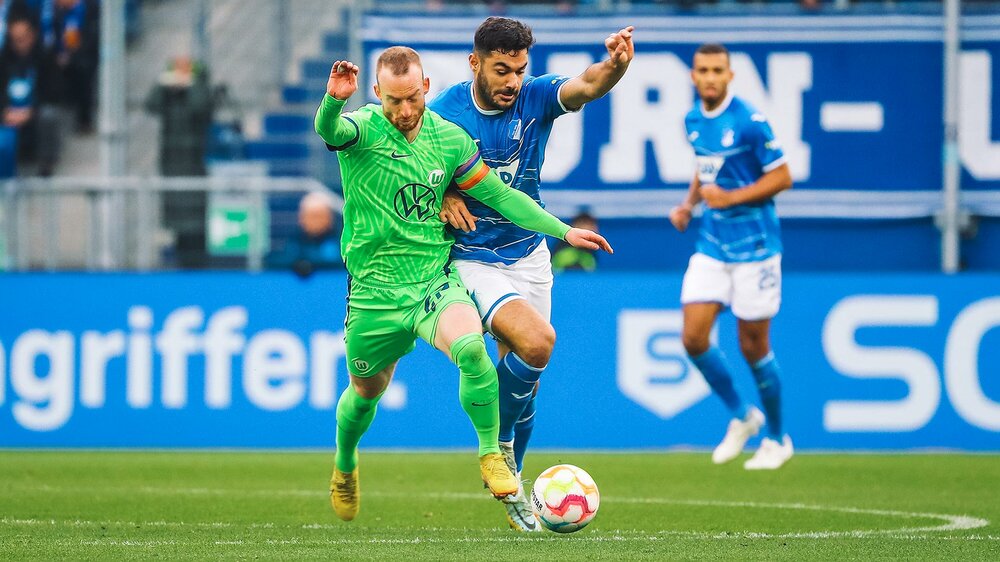 VfL-Wolfsburg-Spieler Maximilian Arnold im Zweikampf mit einem hoffenheimer Gegenspieler.
