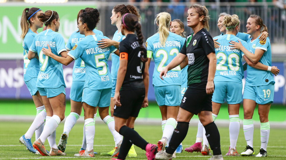 VfL Wolfsburg-Spielerinnen bejubeln einen Treffer auf dem Platz.