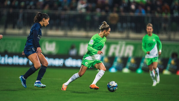VfL Wolfsburg Spielerin Svenja Huth dreht sich von ihrer Mitspielerin davon und läuft mit dem Ball fort.
