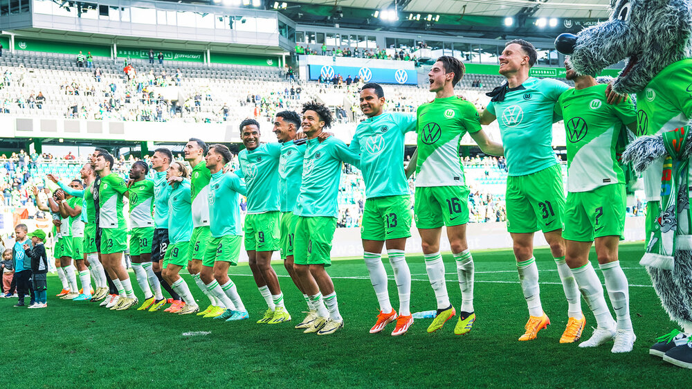 Alle VfL-Wolfsburg-Spieler feiern Arm in Arm nach Abpfiff mit den Fans der Nordkurve.