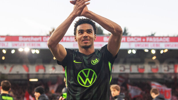 Der VfL-Wolfsburg-Spieler David Odogu klatscht über seinem Kopf in die Hände.