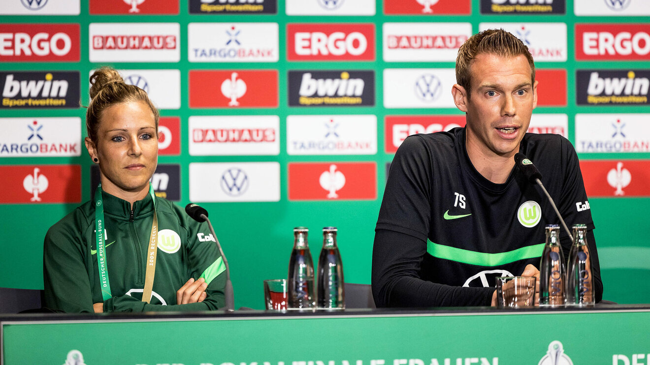 VfL-Wolfsburg Spielerin Svenja Huth und Trainer Tommy Stroot sitzen nebeneinander bei der Pressekonferenz.
