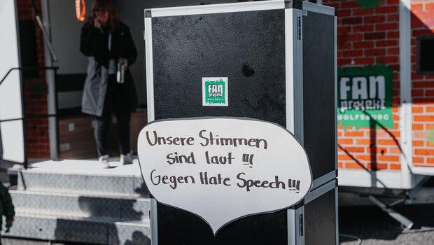 Eine Box mit einem Plakat in Form einer Sprechblase mit einem Text gegen Hass.