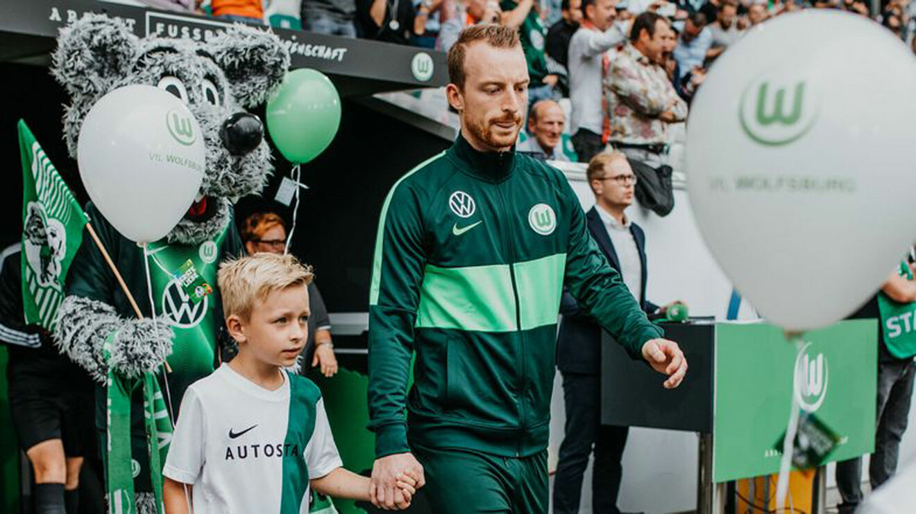 Einlaufkind mit VfL-Wolfsburg-Spieler Arnold.