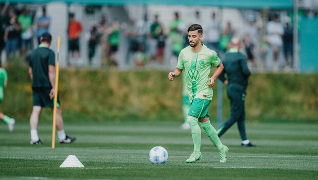 VfL-Wolfsburg-Spieler Mohamed Amoura läuft mit dem Ball zu einem Hütchen.