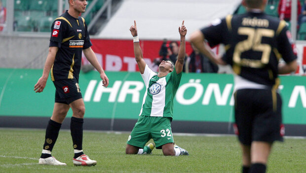 Ein Spieler des VfL Wolfsburg ist auf den Knien und jubelt.