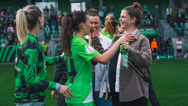 Die beiden VfL-Wolfsburg-Spielerinnen Tabea Sellner und Joelle Wedemeyer umarmen sich. Tabea ist in privater Kleidung und man sieht ihren Babybauch.