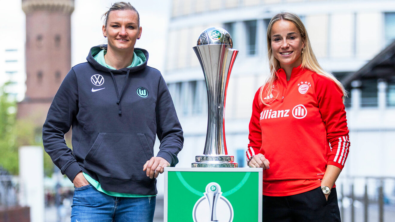 VfL-Wolfsburg-Spielerin Alexandra Popp und Guilia Gwinn posieren zusammen mit dem DFB-Pokal.