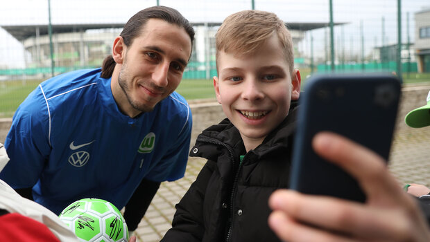 Kamil Grabara posiert für ein Selfie mit einem jungen VfL-Fan.