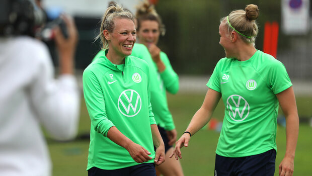 Die VfL Wolfsburg-Spielerinnen Kristin Demann und Pia Wolter lachen auf dem Trainingsplatz.