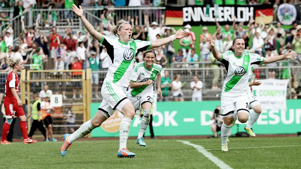 Die Spielerinnen Popp und Maritz vom VfL Wolfsburg rennen jubelnd über das Spielfeld.