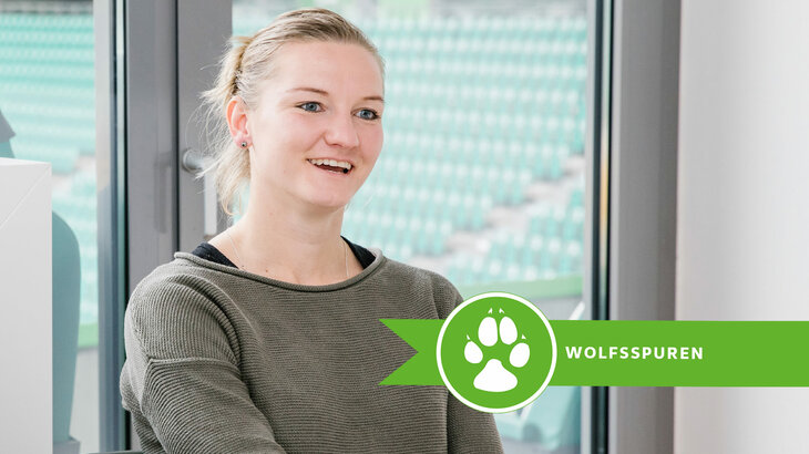 Alexandra Popp wird in einer Loge des VfL Wolfsburg interviewt und erzählt lächelnd etwas über ihre Karriere.