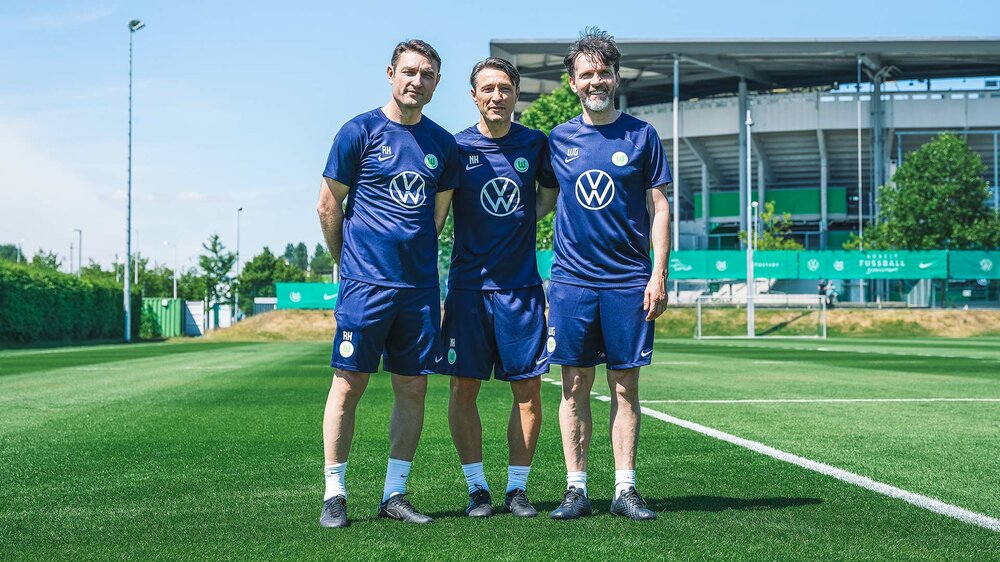 Nowa drużyna trenerska VfL Wolfsburg skupiona wokół Niko Kovaca pozuje przed Volkswagen Arena.