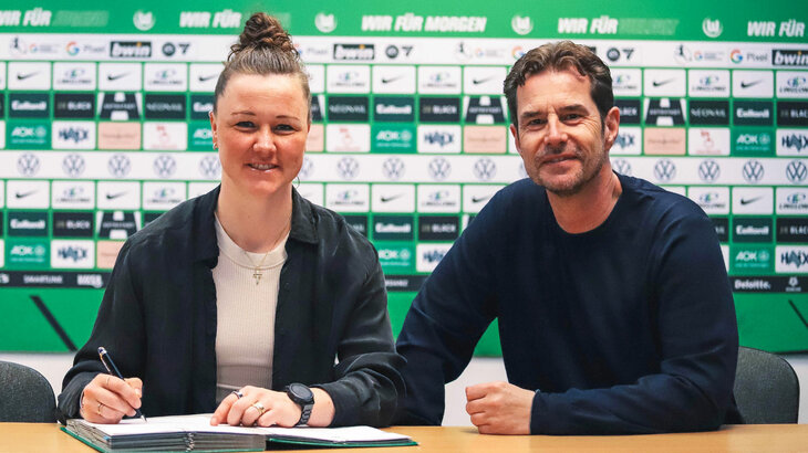 VfL-Wolfsburg-Spielerin Marina Hegering bei der Unterschrift zu ihrer Vertragsverlängerung gemeinsam mit Ralf Kellermann.