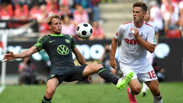 VfL-Wolfsburg-Spieler Cozza im Zweikampf mit einem Köln Spieler.