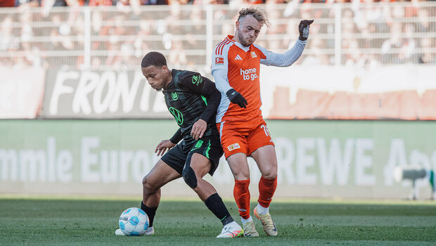 VfL-Wolfsburg-Spieler Aster Vrancks im Zweikampf mit einem Gegenspieler.