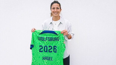 Chantal Hagel ist künftige Spielerin des VfL Wolfsburg und hält ein Trikot in der Hand.