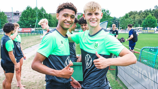 Der Akademie-Spieler des VfL Wolfsburg umarmen sich und zeigen den Daumen hoch.