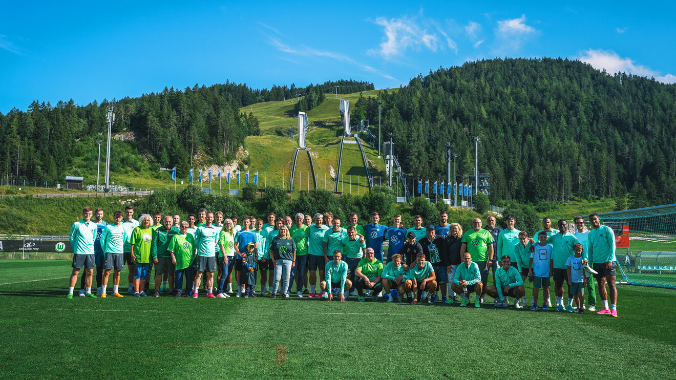 Ein Gruppenbild von Fans und Spielern des VfL Wolfsburg beim Trainingslager des VfL Wolfbsurg.