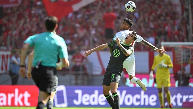 VfL-Wolfsburg-Spieler Zesiger im Zweikampf mit einem Köln Spieler.