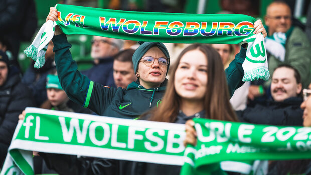 Fans des VfL-Wolfsburg zeigen stolz einen Schal mit dem Motto der Vielfaltsspieltage hoch.