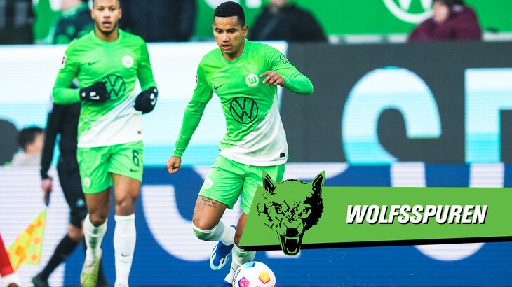 Der VfL-Wolfsburg-Spieler Rogerio läuft hinter dem Ball. Davor liegt eine grüne Grafik mit der Aufschrift "Wolfsspuren".