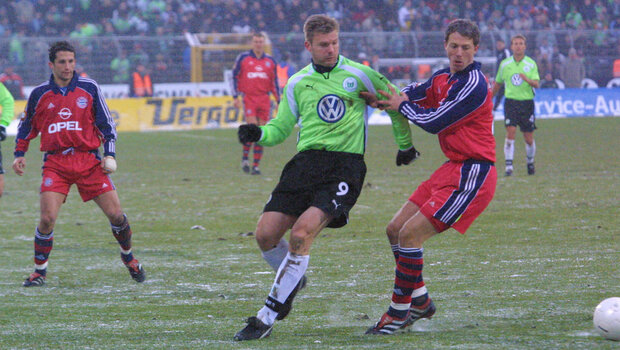 Ein historisches Bild von einem Zweikampf zwischen einem VfL-Wolfsburg-Spieler und einem Bayern-Spieler.