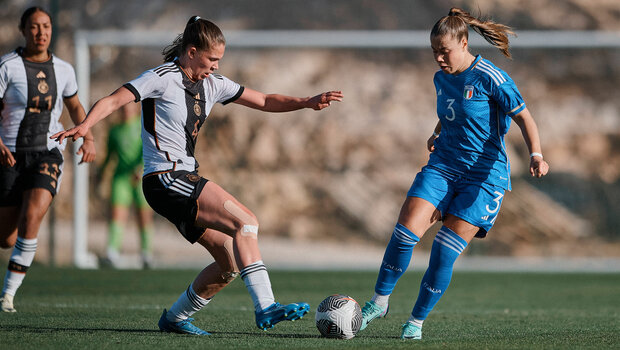 Karla Brinkmann im Zweikampf am Ball im Trikot ihrer Nationalmannschaft.