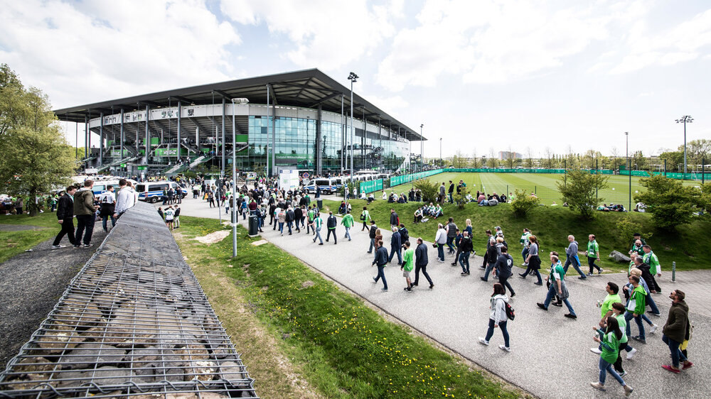 Fans des VfL Wolfsburg laufen zur Volkswagen Arena.