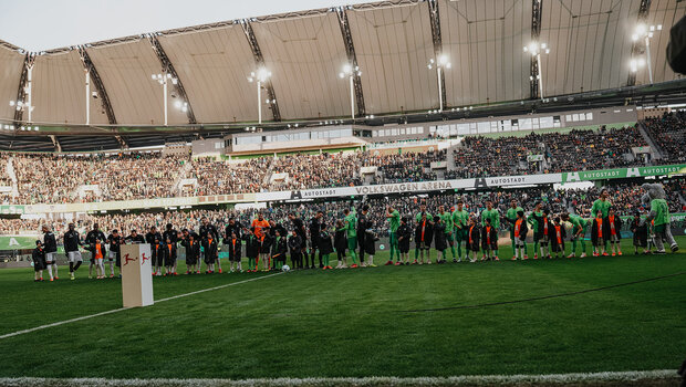 Die Spieler des VfL Wolfsburg und von Bayer Leverkusen stehen in einer Reihe mit den Einlaufkindern.