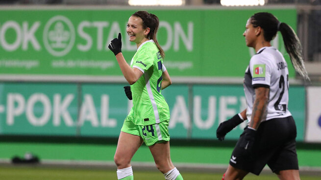 Marie-Joelle zeigt mit dem Finger nach oben und freut sich.