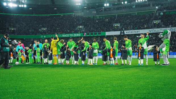 Die VfL-Wolfsburg-Spieler stehen beim Einlaufen auf dem Platz.