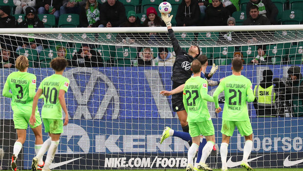VfL-Wolfsburg-Torhüter Casteels versucht einen Schuss zu parieren indem er hoch springt im Spiel gegen Hoffenheim.