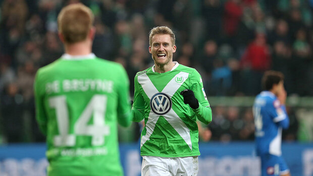 Die VfL Spieler Schürrle und DeBruyne jubeln auf dem Spielfeld.