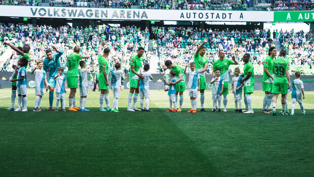Die VfL-Wolfsburg-Spieler winken beim Einlaufen den Fans.