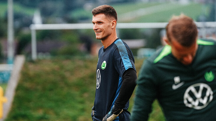 Der VfL-Wolfsburg-Torhüter Pavao Pervan steht lachend auf dem Trainingsplatz.