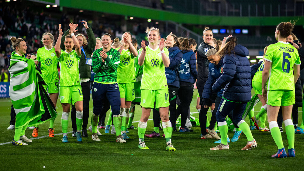 Die VfL Wolfsburg Spielerinnen bejubeln nach dem Spiel einen Sieg auf dem Platz und klatschen für die Fans.