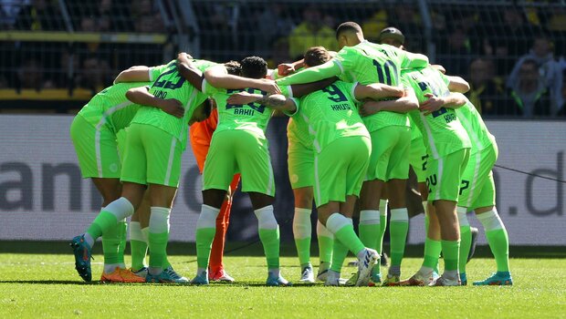 Die Spieler des VfL Wolfsburg bilden einen Kreis.