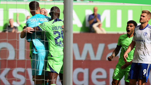 VfL Wolfsburg Spieler Arnold jubelt und umarmt Keeper Casteels nachdem dieser einen Elfmeter gehalten hat.