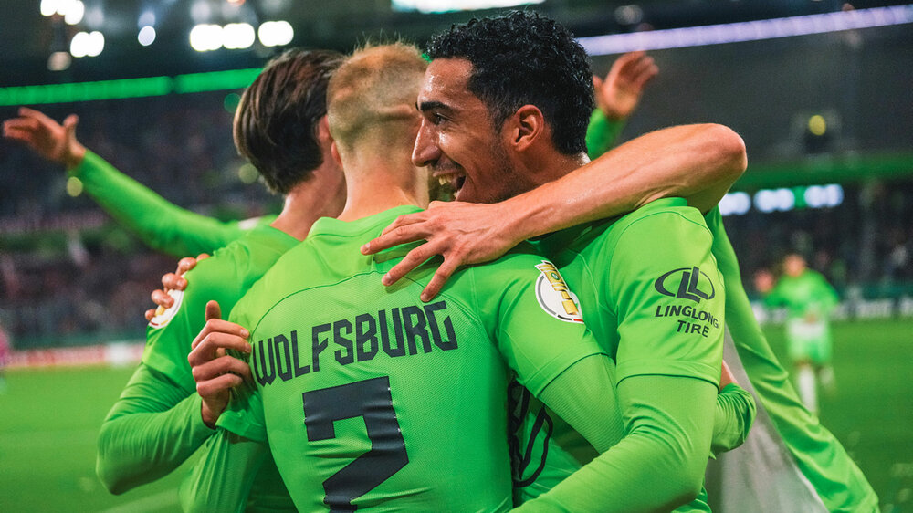 Vaclav Cerny wird von seinen Teamkollegen des VfL Wolfsburg umarmt.