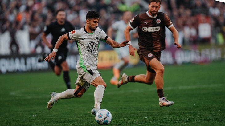 VfL-Wolfsburg-Spieler Mohammed Amoura sprintet mit dem Ball am Fuß an seinem Gegegnspieler vorbei.