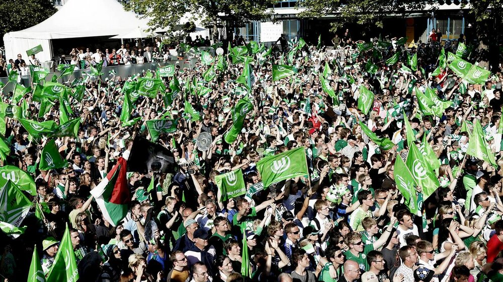 VfL Wolfsburgfans jubeln auf dem Rathausplatz.