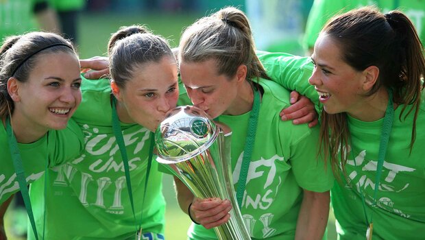 Die Spielerinnen des VfL Wolfsburg freuen sich mit dem DFB Pokal in den Händen.