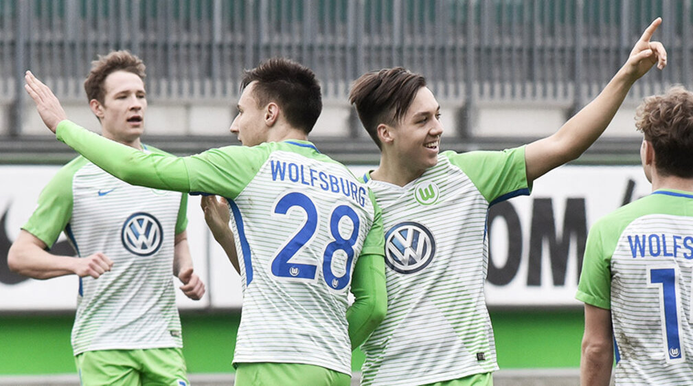 VfL Wolfsburg-Nachwuchskicker Julian Justvan hebt einen Arm und freut sich mit seinen Mannschaftskollegen über sein Tor.