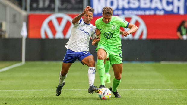VfL Wolfsburg Spieler van de Ven im Zweikampf mit einem Gegner aus Gelsenkirchen.